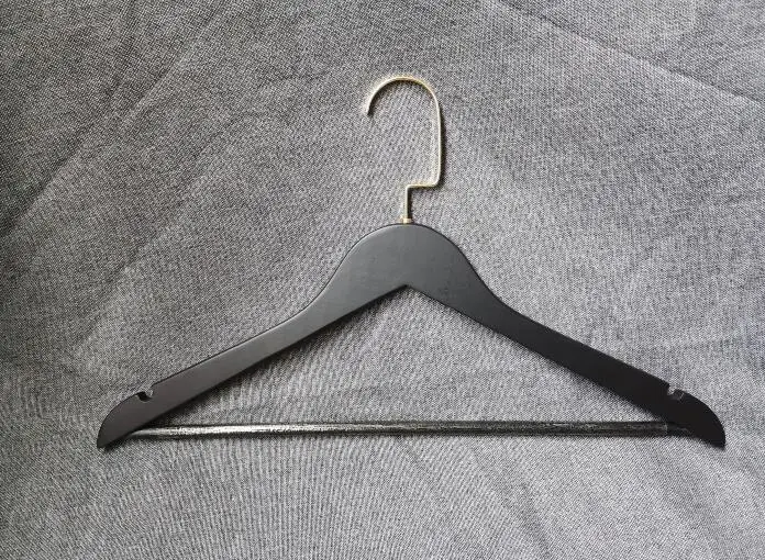Black wooden hanger with gold hook and botoom round bar