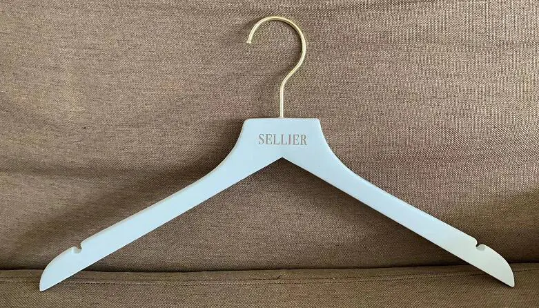 white hangers with gold metal and cusotmized brand logo